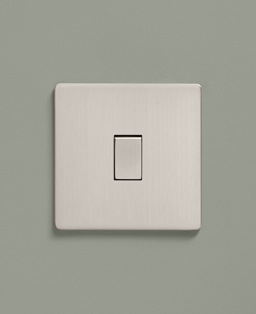 brushed silver rocker light switch with silver rocker on a sage green background