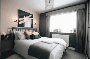 pink and dark green bedroom with white bedding and bramley wall lights