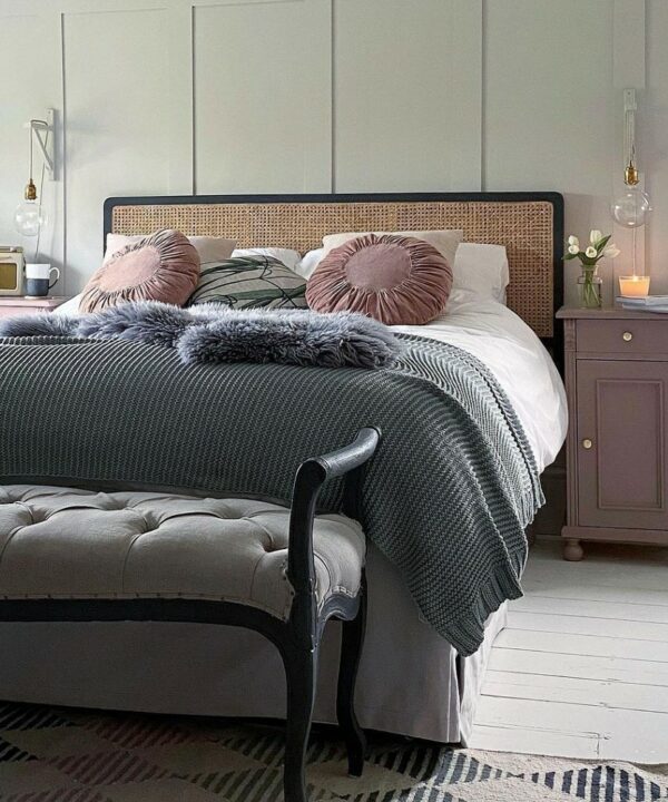 customised bedside lamps using gold bulb holders, clear globe light bulbs and linen fabric cable besides a rattan bed in an off-white, pale pink and grey bedroom
