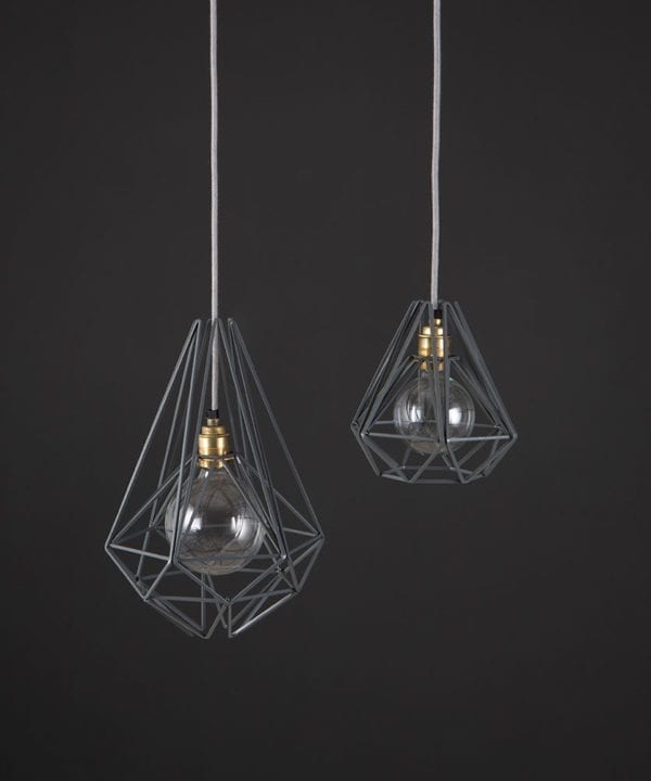 metal cage ceiling grey two black metal diaamond shaped cage light shades with smoked gold bulb holders suspended from felt grey fabric cable against dark grey wall