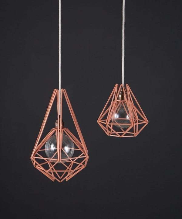 metal ceiling light pink chai two pink metal diamond shaped cage light shades with copper bulb holders suspended from linen fabric cable against dark grey wall