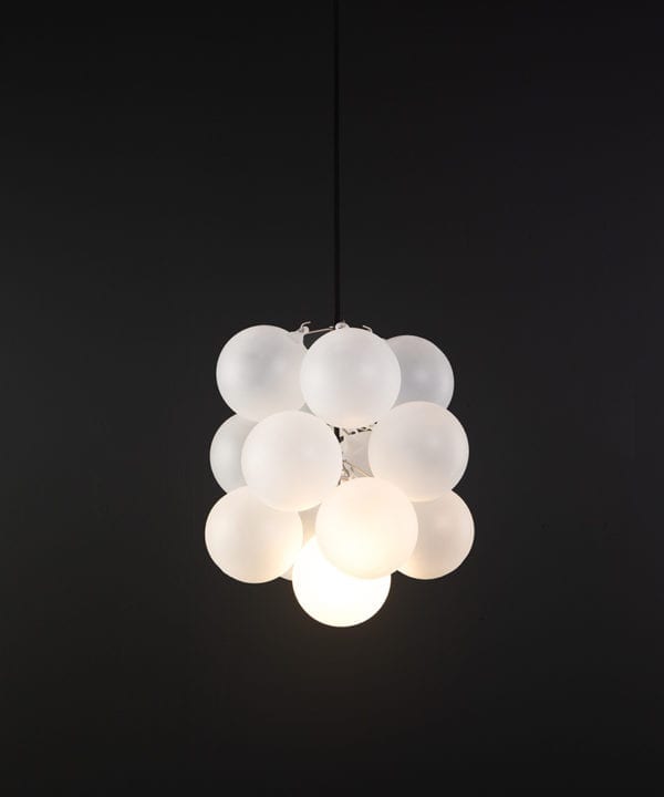 frosted glass bubble chandelier with 16 glass orbs and 1 silver bulb holder suspended from black cable against a black wall