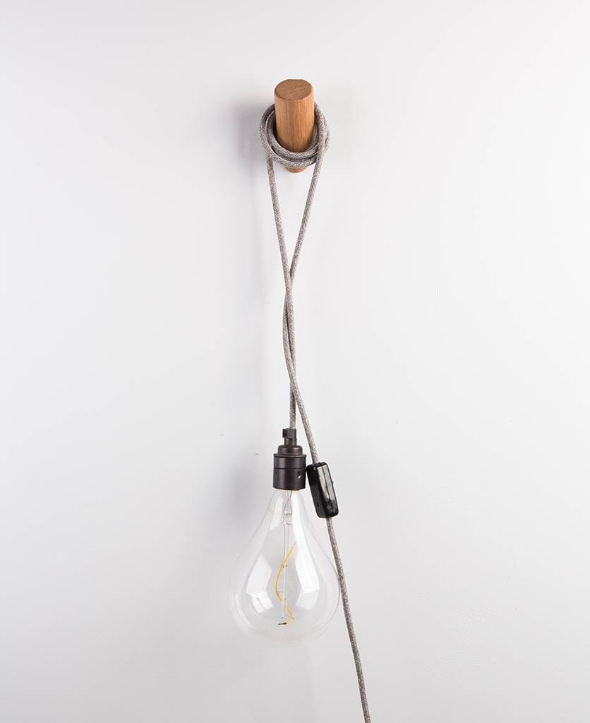 peg wall light draped around wooden peg on white wall