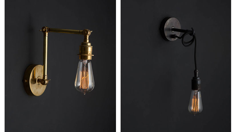 fender brass wall light and angler black wall light against black background