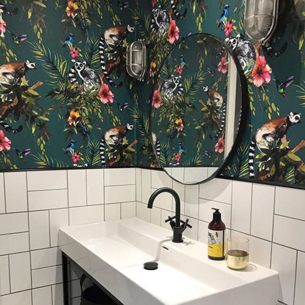 dave silver bulkhead light against teal floral wallpaper in a bathroom