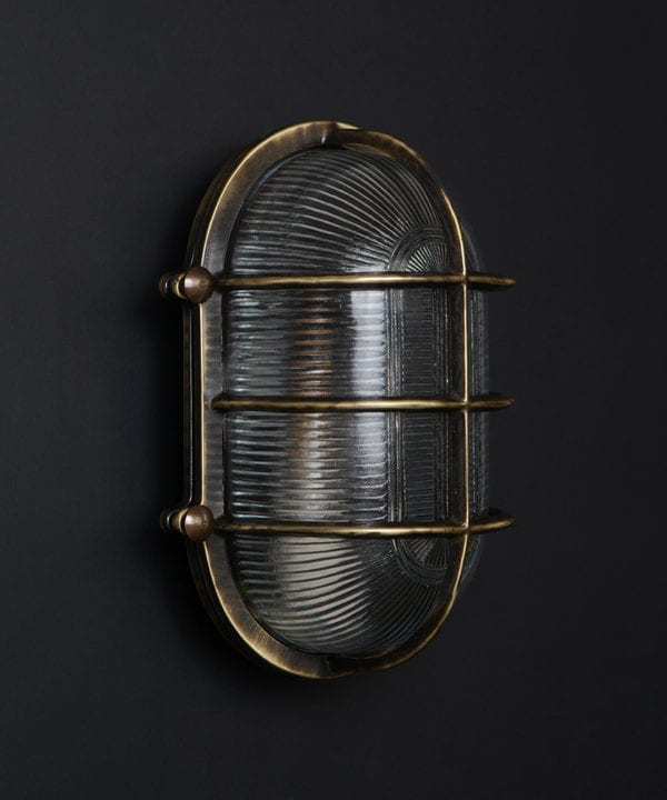 unlit aged brass big steve bulkhead on black background