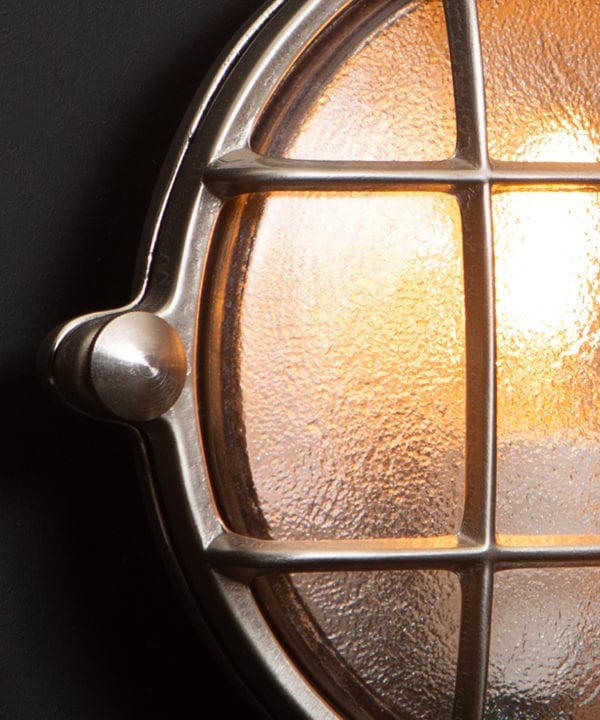 Mark silver bulkhead light close up against black wall