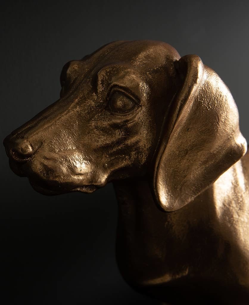 closeup of black and gold Fred dachshund table lamp against black backgorund