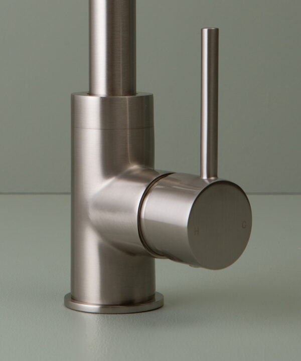 silver kintampo tap handle close up on grey-green background