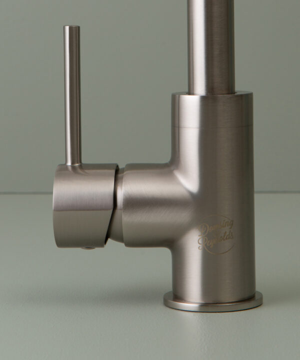 silver kintampo tap logo and handle close up on grey-green background