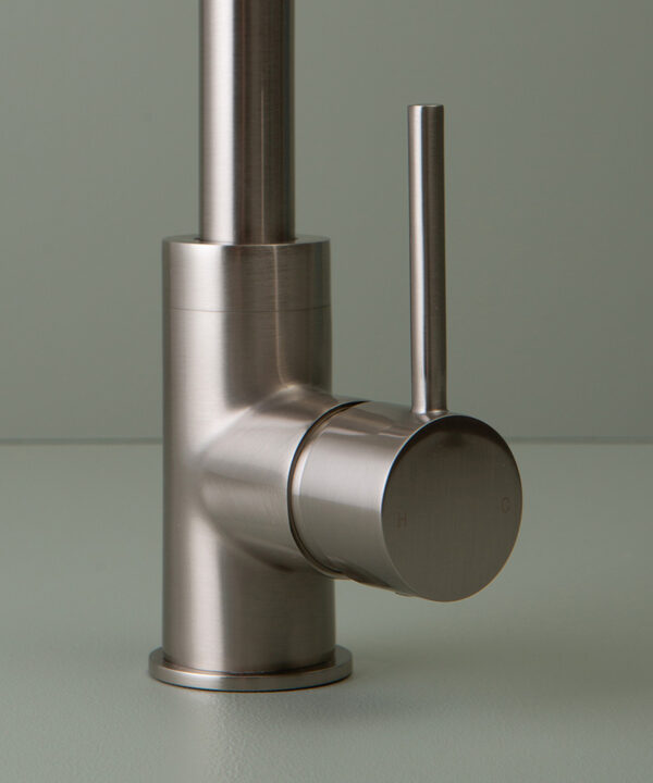 close up of silver tinkisso tap handle on grey-green background