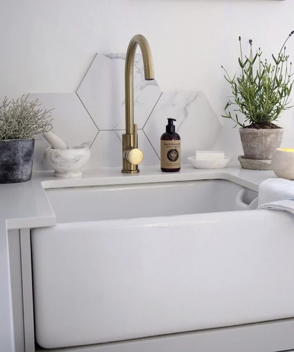 Gold Tinkisso tap over a white basin.
