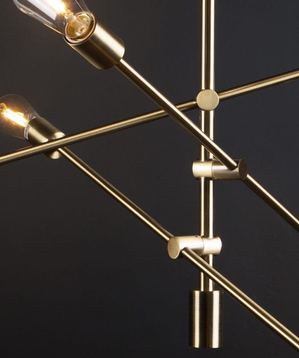 brass feature pendant lights with clear pear bulbs close up against black background