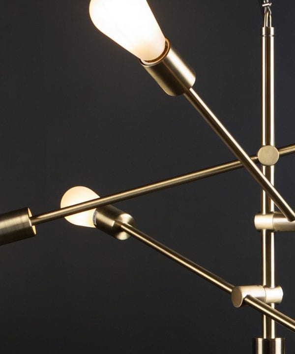 brass feature pendant lights with frosted pear bulbs close up against black background