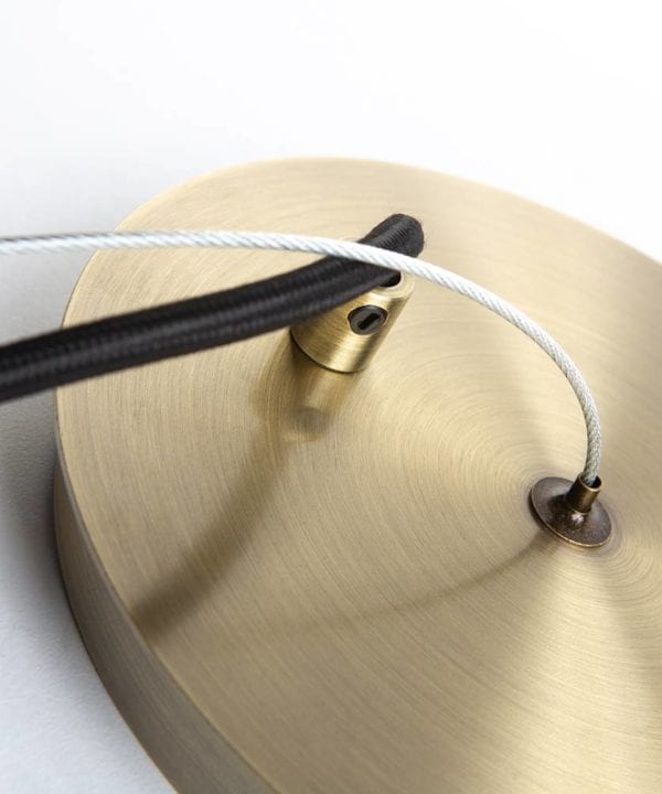 closeup of trikonasana gold ceiling rose with silver suspension wire on white background