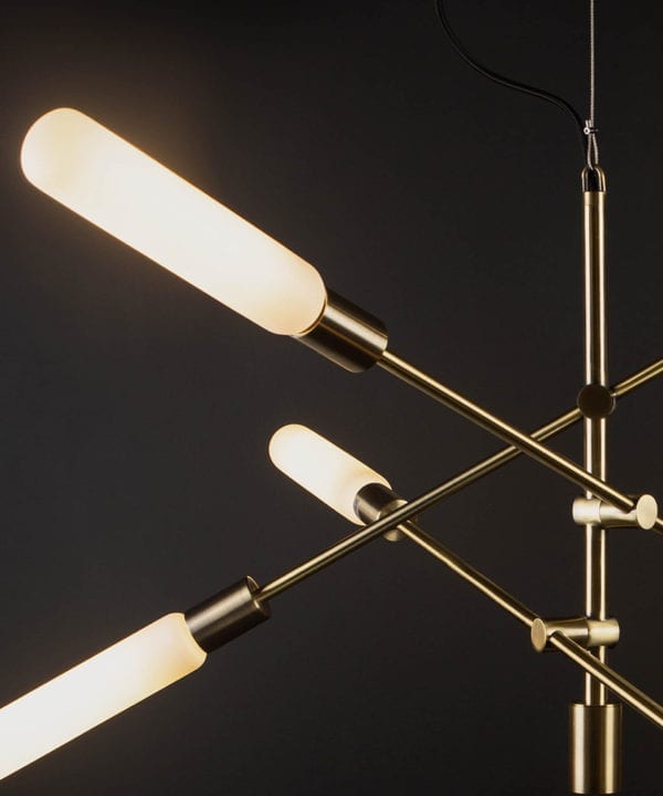 close up of brass feature pendant lights with luna opal bulbs on black background
