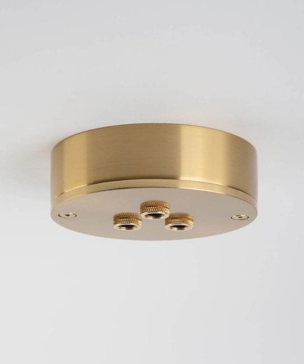 three point raw brass ceiling rose against white background
