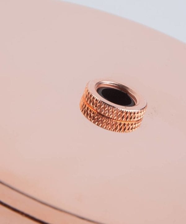 closeup of polished copper ceiling rose against ahite background