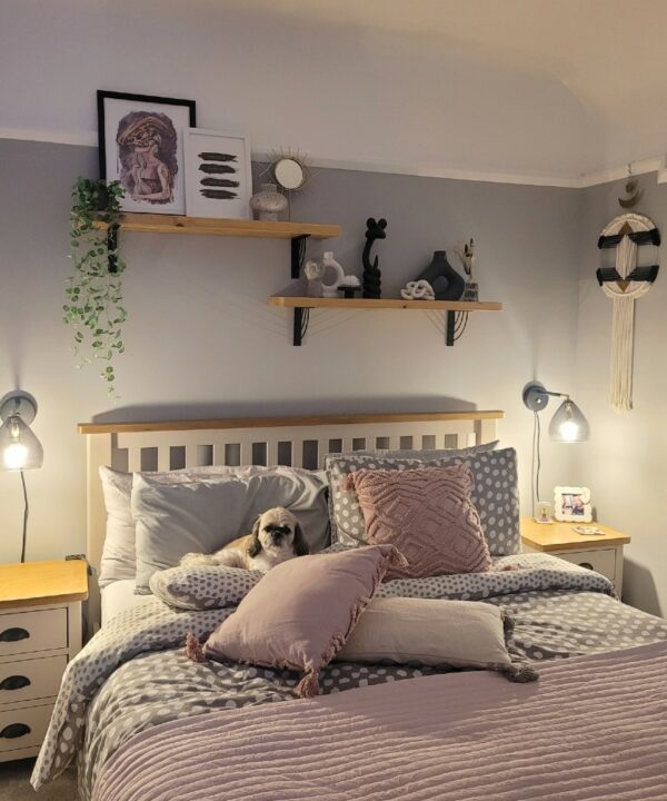 two wooden shales supported by Marilyn shelf brackets above a bed