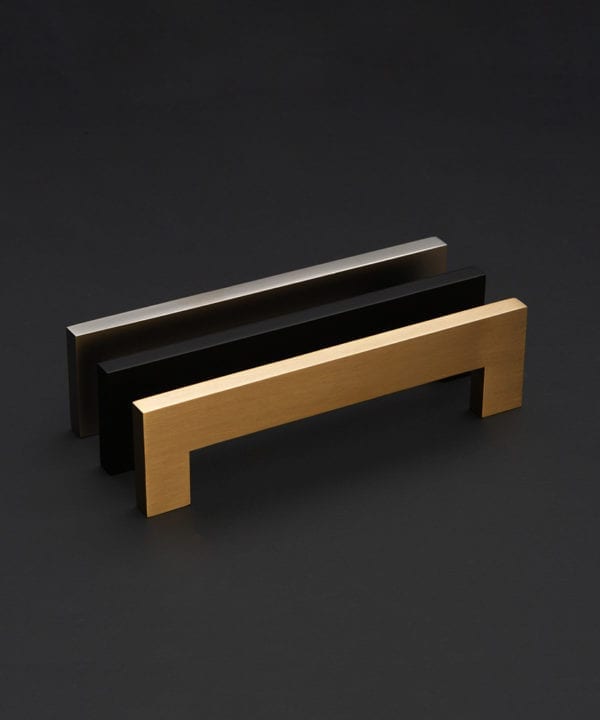 square door handles in gold, silver and black against a black background