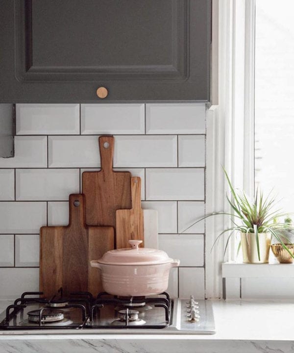 brass modernist large knob on dark grey cupboard in a grey and white kitchen