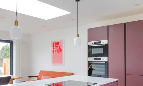 two pandora opal square bulbs suspended from gold bulb holder and black fabric cable in white and pink kitchen
