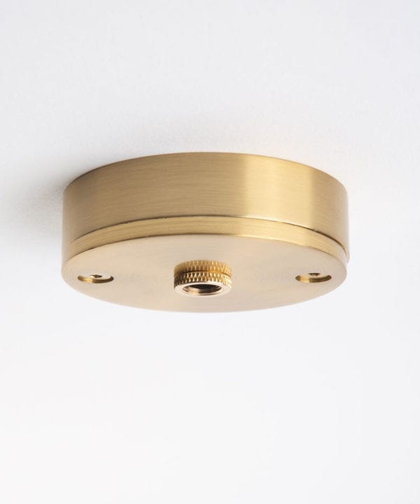 small raw brass ceiling rose against white background