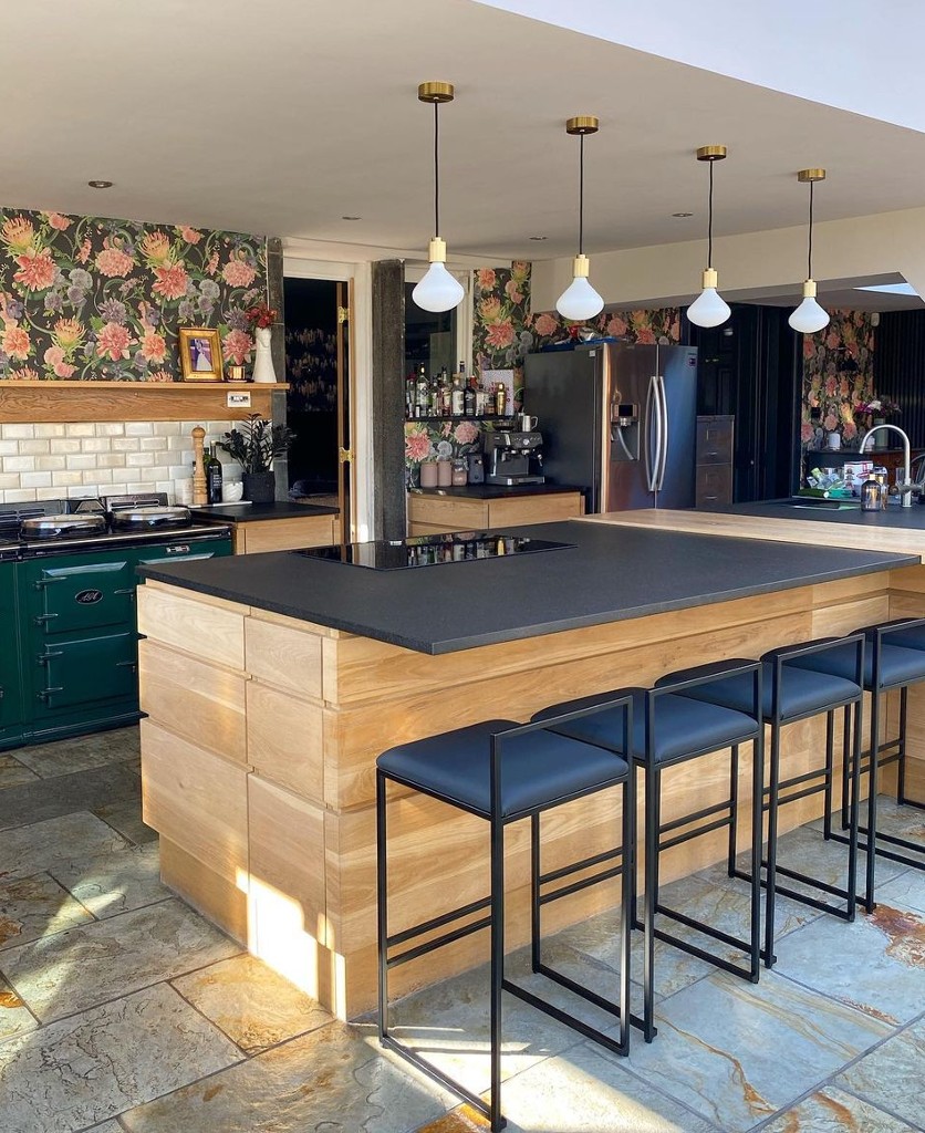 four gold lanesborough pendant lights suspended along the length of a wooden and grey kitchen island