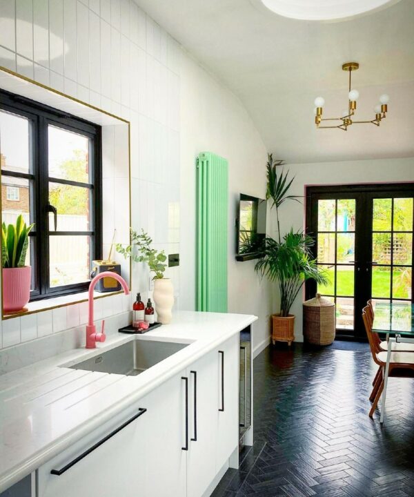 pink tinkisso tap installed in a white and black kitchen