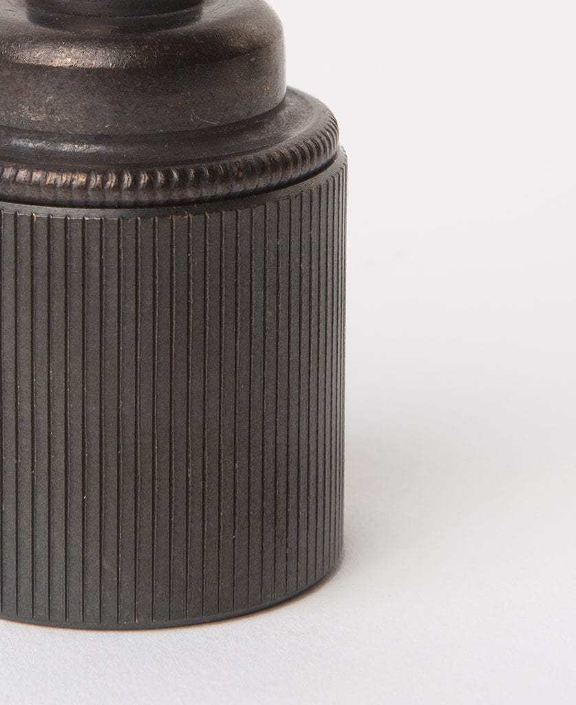 closeup of antique black e27 light bulb holder against grey background
