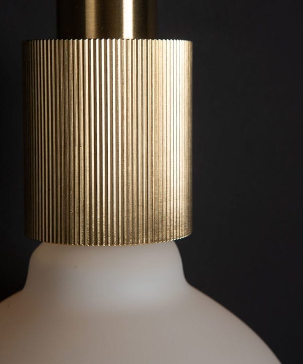 brass ribbed bulb holder against black wall