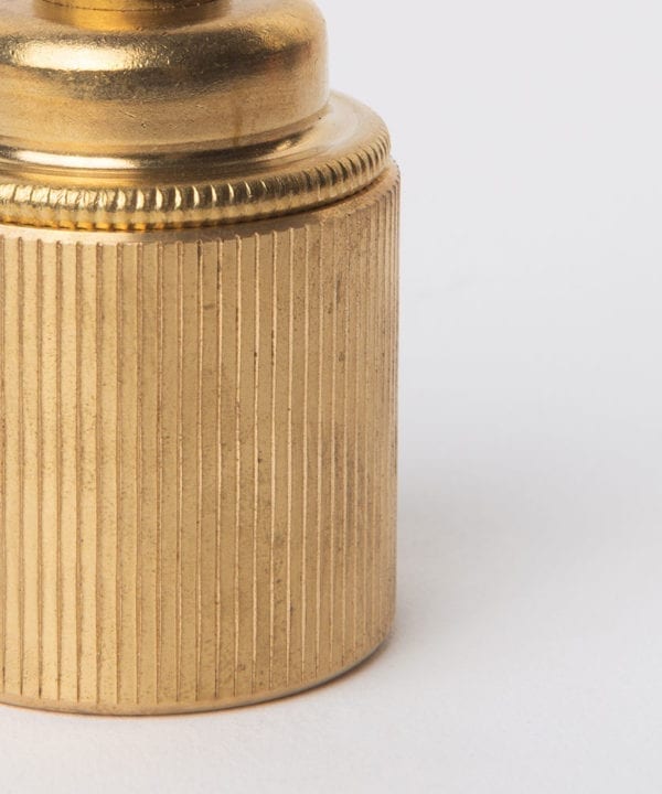 closeup of e27 raw brass lamp holderwith ribbed detail against white background