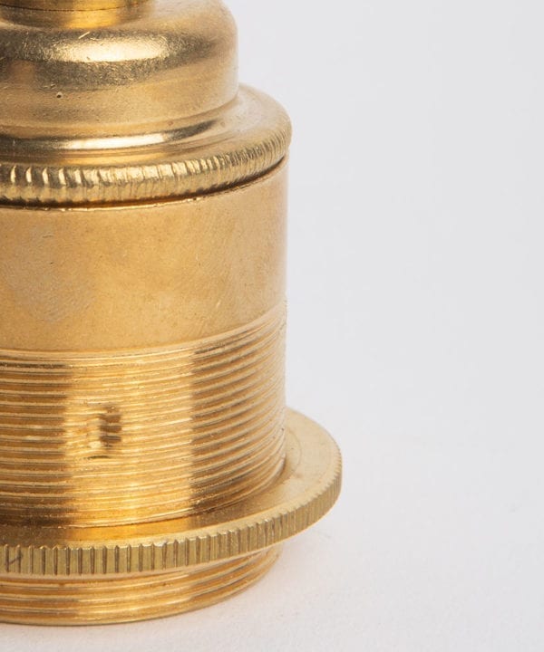 closeup of e27 threaded raw brass bulb holder against white background