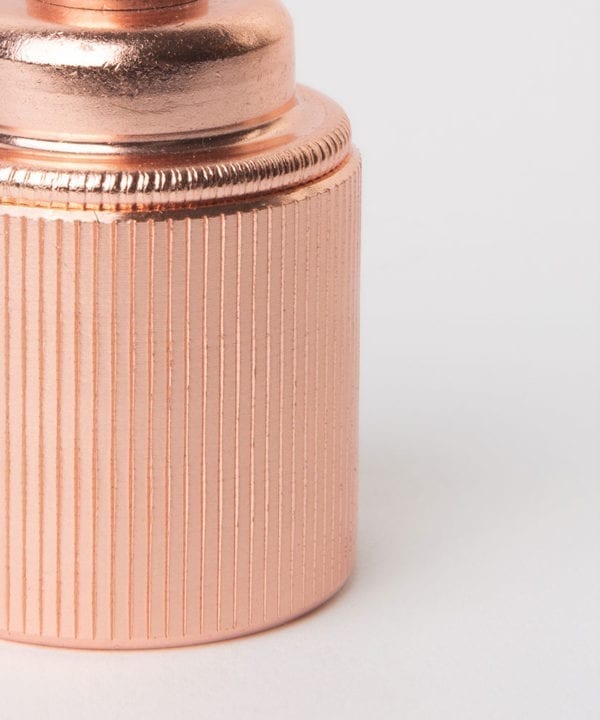 closeup of polished copper e27 ribbed screw lamp holder against white background
