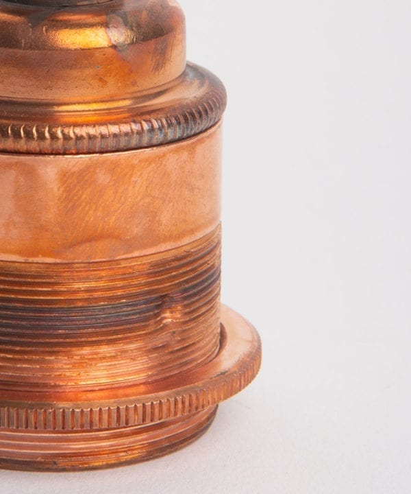 closeup of tarnished copper threaded e27 bulb holders against white background