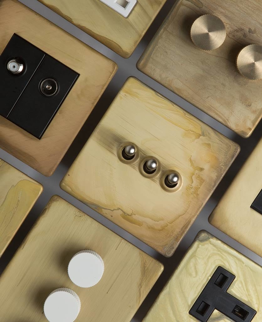 flatlay of smoked gold dimmers, toggles and sockets against grey background