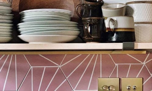 brass double dimmer, double toggle and double usb socket in a pink tiled kitchen