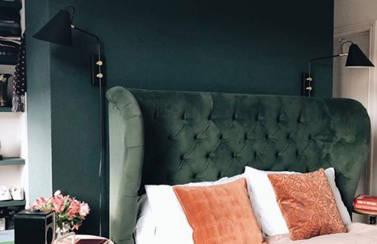 dark green velvet headboard against dark green wall