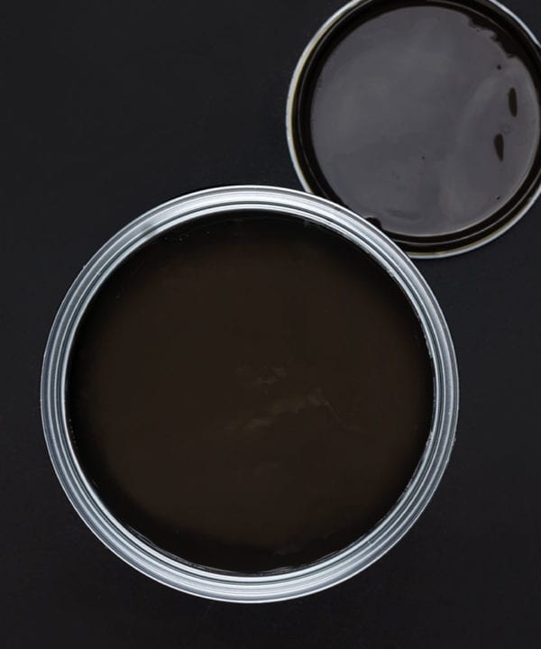 Mud wrestling dark brown paint tin on dark background