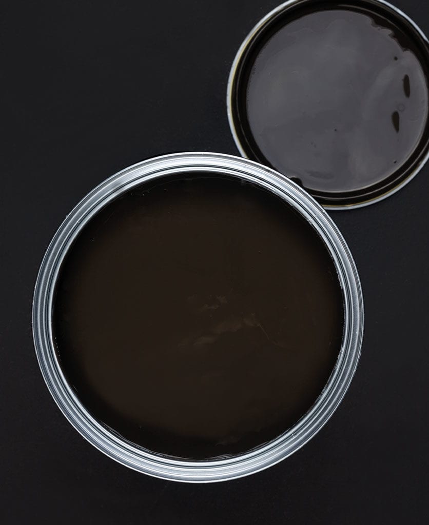 Mud wrestling dark brown paint tin on dark background