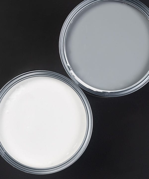 Grey and white paint primer tins on black background