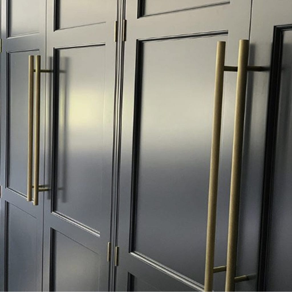 brass skyscraper handles on panelled blue wardrobe doors