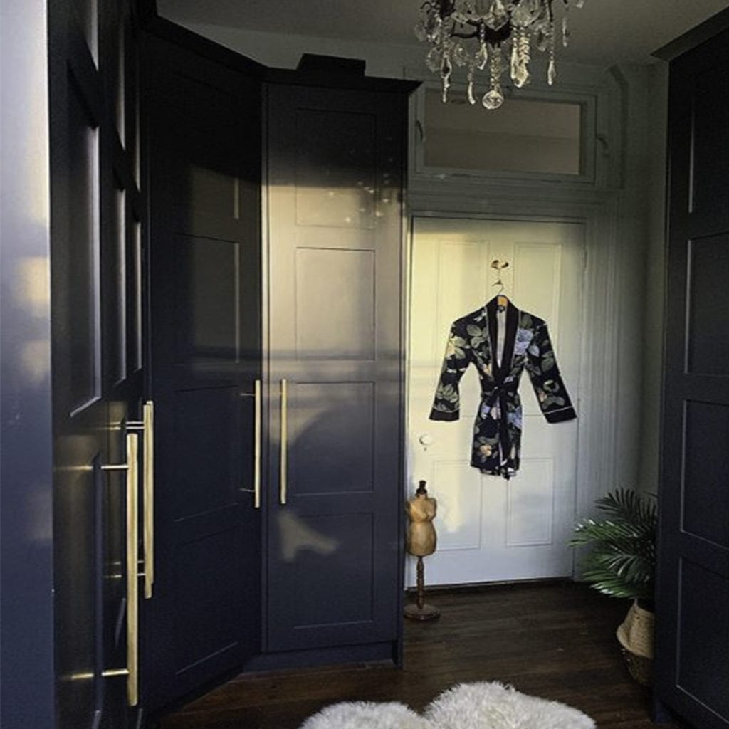 brass skyscraper handles on dark blue cupboards in a blue and white bedroom