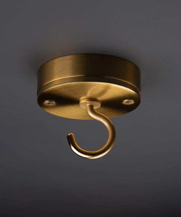 raw gold ceiling hook against black background