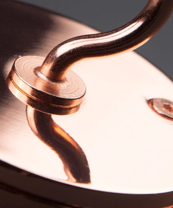 closeup of polished copper ceiling hook against black background