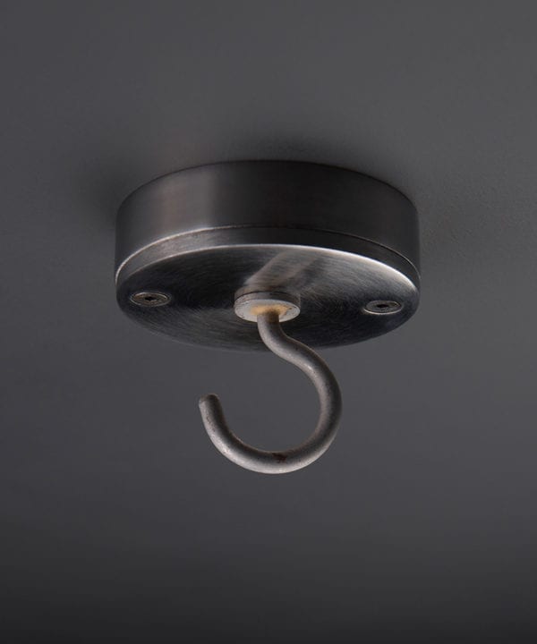 raw steel ceiling hook against black background