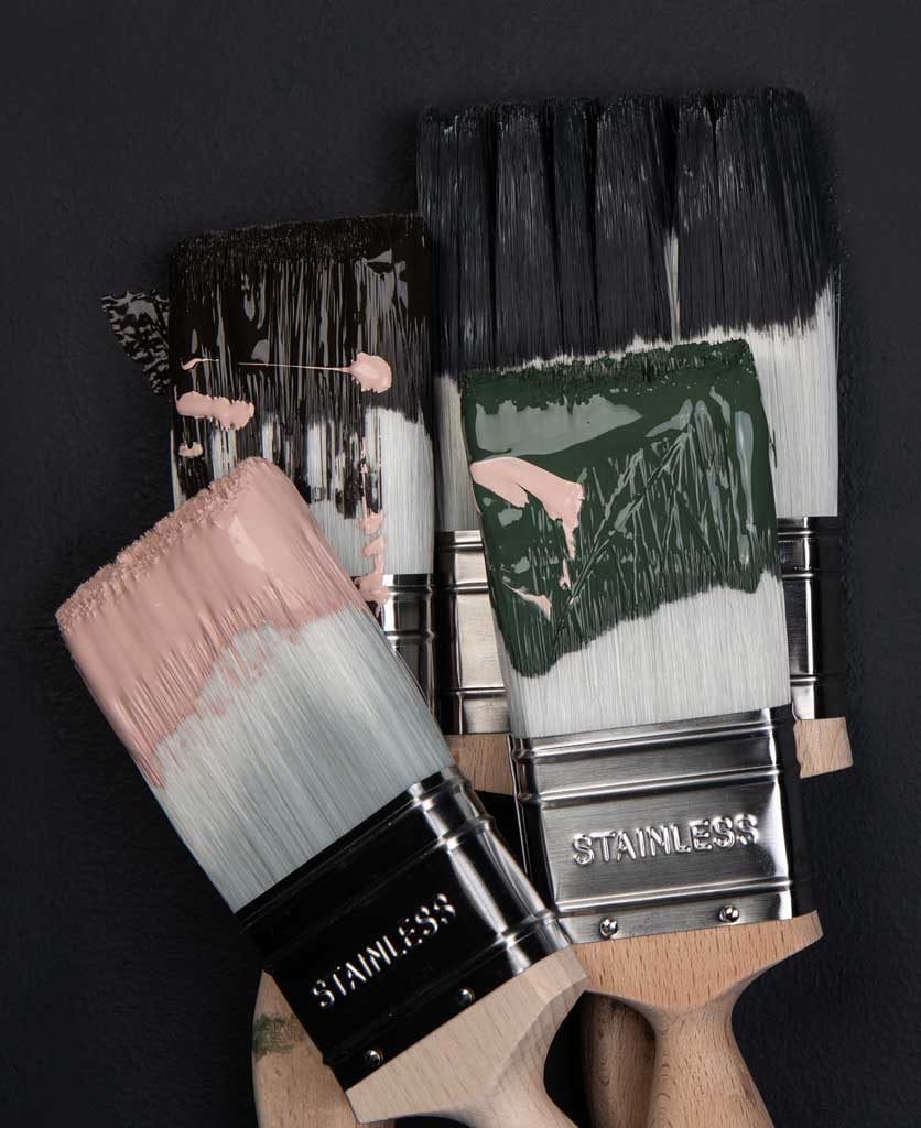 four paintbrushes with get plastered, spruce things up and all the lights off paint against black background