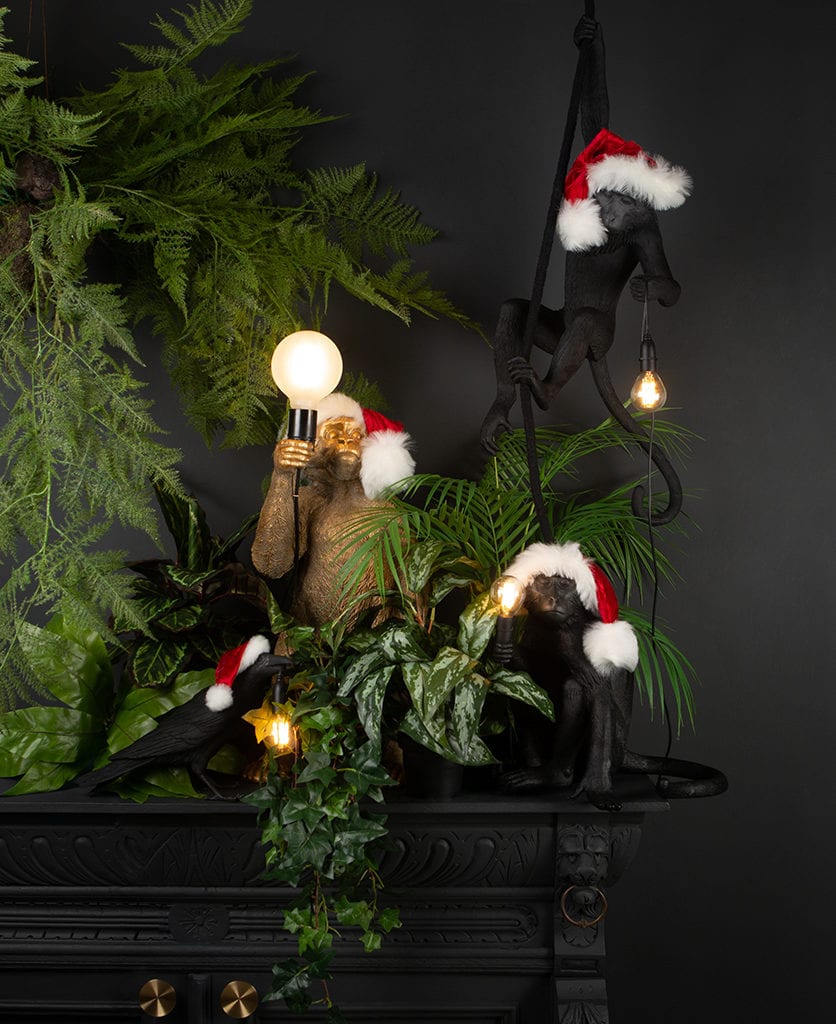 collection of monkey lamps wearing santa hats against a black background