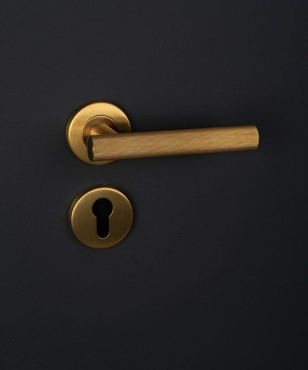 kramer gold internal handle with escutcheon on black background