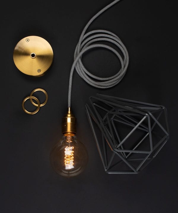bespoke light fittings gold ceiling rose with grey cage light shade, grey fabric cable, bulb holder and lit bulb on black background